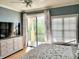 Well-lit bedroom features sliding glass doors to a patio with privacy blinds and shades at 6407 Mayra Shores Ln, Apollo Beach, FL 33572