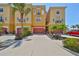Beautiful multi-story townhomes with driveways and red garage doors, surrounded by lush landscaping at 6407 Mayra Shores Ln, Apollo Beach, FL 33572