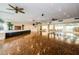 Large ballroom with parquet floors, ceiling fans, and a stage with speakers at 7700 Sun Island S Dr # 404, South Pasadena, FL 33707