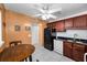 Kitchen featuring dark wood cabinets, white appliances, black refrigerator, and a breakfast table at 7700 Sun Island S Dr # 404, South Pasadena, FL 33707