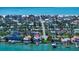 Picturesque aerial view showcasing waterfront homes nestled near a sandy beach and clear blue ocean waters at 785 Bay Esplanade, Clearwater Beach, FL 33767