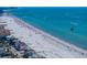 An aerial view showcases the property's proximity to the beach, with bright umbrellas dotting the shoreline at 785 Bay Esplanade, Clearwater Beach, FL 33767