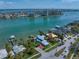 Attractive aerial shot of waterfront houses with docks, nestled in a green landscape, with a city skyline in the distance at 785 Bay Esplanade, Clearwater Beach, FL 33767