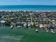 Panoramic aerial shot showcasing waterfront homes, docks, and a beach, set against the backdrop of the calm ocean at 785 Bay Esplanade, Clearwater Beach, FL 33767