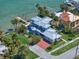 Stunning aerial view of a luxury home with a metal roof, a brick driveway, and lush tropical landscaping at 785 Bay Esplanade, Clearwater Beach, FL 33767