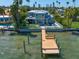 Stunning waterfront home with a wooden dock, pool, and outdoor seating area, perfect for enjoying the waterfront lifestyle at 785 Bay Esplanade, Clearwater Beach, FL 33767