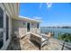 Outdoor balcony with tile flooring, a seating area, and views of the water at 785 Bay Esplanade, Clearwater Beach, FL 33767
