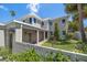 Charming two-story home with a partially covered porch, lush green lawn, and privacy wall at 785 Bay Esplanade, Clearwater Beach, FL 33767
