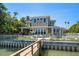 Beautiful waterfront home boasts a private dock, manicured lawn, and an inviting outdoor living space at 785 Bay Esplanade, Clearwater Beach, FL 33767