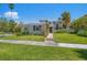 Charming two-story home featuring a well-maintained lawn, lush landscaping, and a welcoming walkway to the front entrance at 785 Bay Esplanade, Clearwater Beach, FL 33767