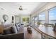 Bright living room boasts hardwood floors, fan, and sliding doors to the outdoor spaces and water views at 785 Bay Esplanade, Clearwater Beach, FL 33767