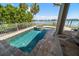 Inviting in-ground pool and spa with stone surround overlooks waterfront at 785 Bay Esplanade, Clearwater Beach, FL 33767