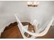 Spiral staircase featuring wood treads, white risers, a white handrail, and elegant chandelier at 785 Bay Esplanade, Clearwater Beach, FL 33767