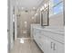 Bright bathroom with a double vanity, large mirror, and glass shower at 923 Seagrape Dr, Ruskin, FL 33570