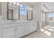 Modern bathroom with double vanity sinks, marble countertops, and natural light from the windows at 923 Seagrape Dr, Ruskin, FL 33570