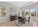 Cozy dining area with a round table, black chairs, and natural light from large windows at 923 Seagrape Dr, Ruskin, FL 33570