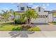 Stunning two-story home showcasing a manicured lawn and lush palm trees, creating a tropical paradise at 923 Seagrape Dr, Ruskin, FL 33570