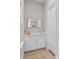 Hallway with a vanity, mirror, white cabinets, and luxury vinyl plank flooring at 923 Seagrape Dr, Ruskin, FL 33570