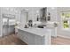Modern kitchen with white cabinets, stainless steel appliances, and a large center island at 923 Seagrape Dr, Ruskin, FL 33570