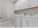 Bright laundry room featuring white cabinetry, sink, washer, and dryer at 923 Seagrape Dr, Ruskin, FL 33570