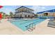 Community pool featuring lounge chairs, landscaping, and a community building at 923 Seagrape Dr, Ruskin, FL 33570