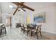 Open dining room with wood-look tile, a vaulted ceiling, exposed beams, and a decorative painting at 11467 93Rd St, Largo, FL 33773