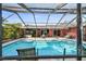 Relaxing screened-in pool surrounded by patio space and views of the home's back exterior at 11467 93Rd St, Largo, FL 33773