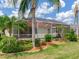 View of the screened lanai, pool and tropical landscaping from the back yard at 1167 Lindenwood Dr, Tarpon Springs, FL 34688