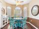 Bright breakfast nook features bay windows, plantation shutters, and stylish turquoise chairs at 1167 Lindenwood Dr, Tarpon Springs, FL 34688