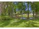 Lush backyard featuring mature trees, a serene pond, and manicured lawn, creating a tranquil outdoor setting at 1203 Parrilla De Avila, Tampa, FL 33613