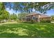 Expansive backyard featuring a screen enclosed patio and view of the lush lawn and mature trees at 1203 Parrilla De Avila, Tampa, FL 33613