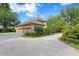 Paver driveway leads to a three-car garage, surrounded by mature landscaping and lush greenery at 1203 Parrilla De Avila, Tampa, FL 33613