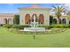A beautiful front yard is adorned with a lovely water fountain, flowers and mature landscaping at 1203 Parrilla De Avila, Tampa, FL 33613