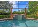 Close-up of the pool showing a cascading waterfall feature, clear blue water, and surrounding lush greenery at 1203 Parrilla De Avila, Tampa, FL 33613