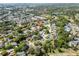 Scenic aerial view showcasing a residential neighborhood with mature trees and nearby golf course at 12808 Candlewood Way, Hudson, FL 34667