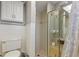 Shower with a frosted glass door adjoins to a toilet and cabinet featuring decorative tile walls at 12808 Candlewood Way, Hudson, FL 34667