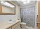 Bathroom featuring a sink and vanity, toilet, and a shower tub combo with neutral colored tile at 12808 Candlewood Way, Hudson, FL 34667
