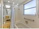 Bathroom featuring a shower and tub combo with a window for natural light and safety bars at 12808 Candlewood Way, Hudson, FL 34667