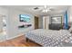 Bedroom with ceiling fan, wood floors, closet, flat screen tv, and attached full bathroom at 12808 Candlewood Way, Hudson, FL 34667