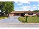 Charming single-story home featuring a well-manicured lawn and a long, paved driveway leading to the residence at 12808 Candlewood Way, Hudson, FL 34667