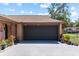 Attached two-car garage featuring a dark brown door and well maintained driveway with landscaping at 12808 Candlewood Way, Hudson, FL 34667