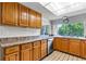 Kitchen with wooden cabinets, stainless steel appliances, and a large window overlooking the backyard at 12808 Candlewood Way, Hudson, FL 34667