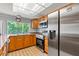 Well-lit kitchen featuring a stainless steel refrigerator, oven, and a window above the sink at 12808 Candlewood Way, Hudson, FL 34667