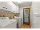 Efficient laundry room with washer, dryer, sink, storage cabinets, and exterior access at 12808 Candlewood Way, Hudson, FL 34667