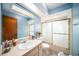 Bathroom featuring blue walls, a vanity, and a glass-enclosed shower at 1371 Meredith Dr, Spring Hill, FL 34608