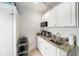Galley kitchen with white cabinets and granite countertops at 1371 Meredith Dr, Spring Hill, FL 34608