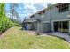 View of the grassy backyard with privacy fence and a sliding glass door to indoor living space at 14053 Notreville Way, Tampa, FL 33624