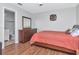 Cozy bedroom featuring wood-look floors, a dresser, and an attached bathroom at 14053 Notreville Way, Tampa, FL 33624