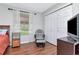Inviting bedroom with a rocking chair, wood floors, and closet with white bi-fold doors at 14053 Notreville Way, Tampa, FL 33624