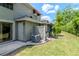 View of home exterior with an AC unit, patio and green space at 14053 Notreville Way, Tampa, FL 33624